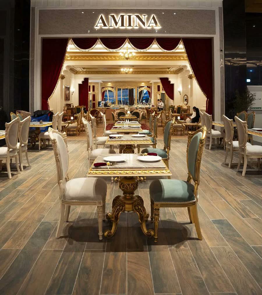 The Amina entrance at Reem Mall: the glowing name over red theatre curtains and gold tables