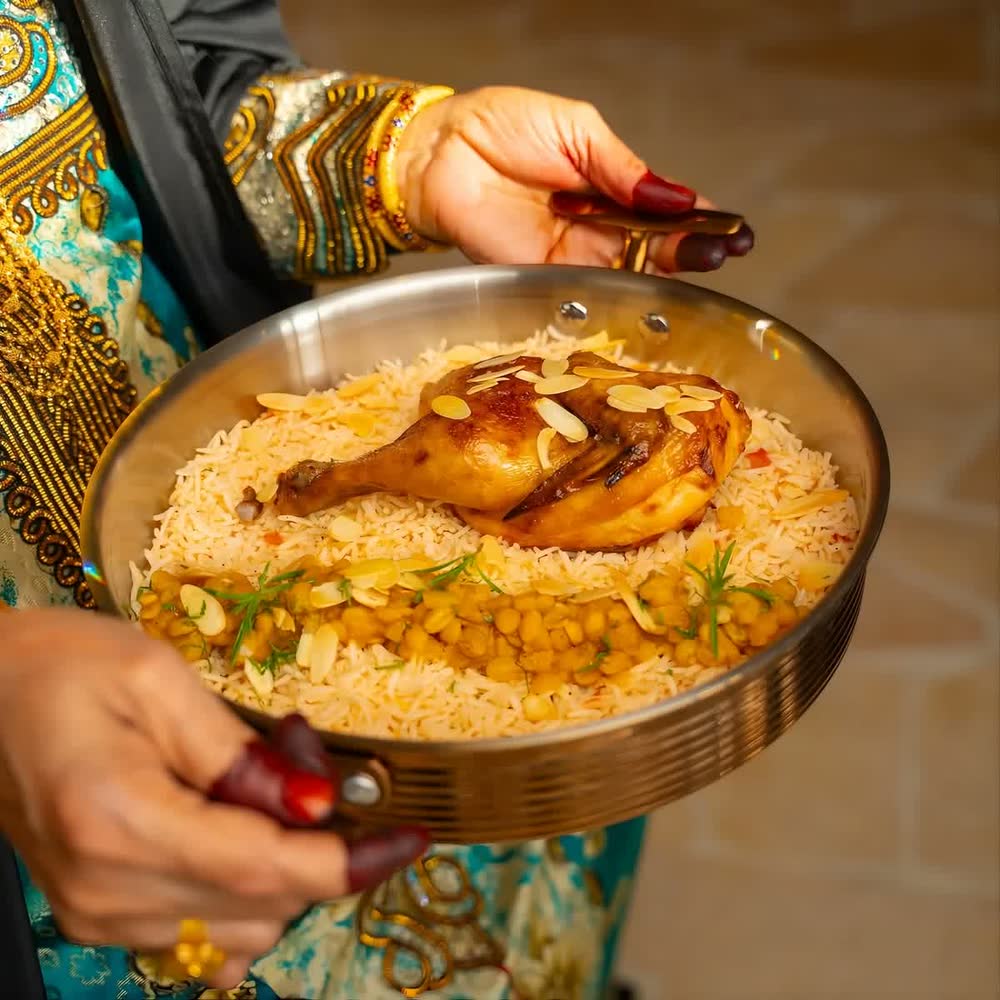 A pan of Emirati machboos carried to the table